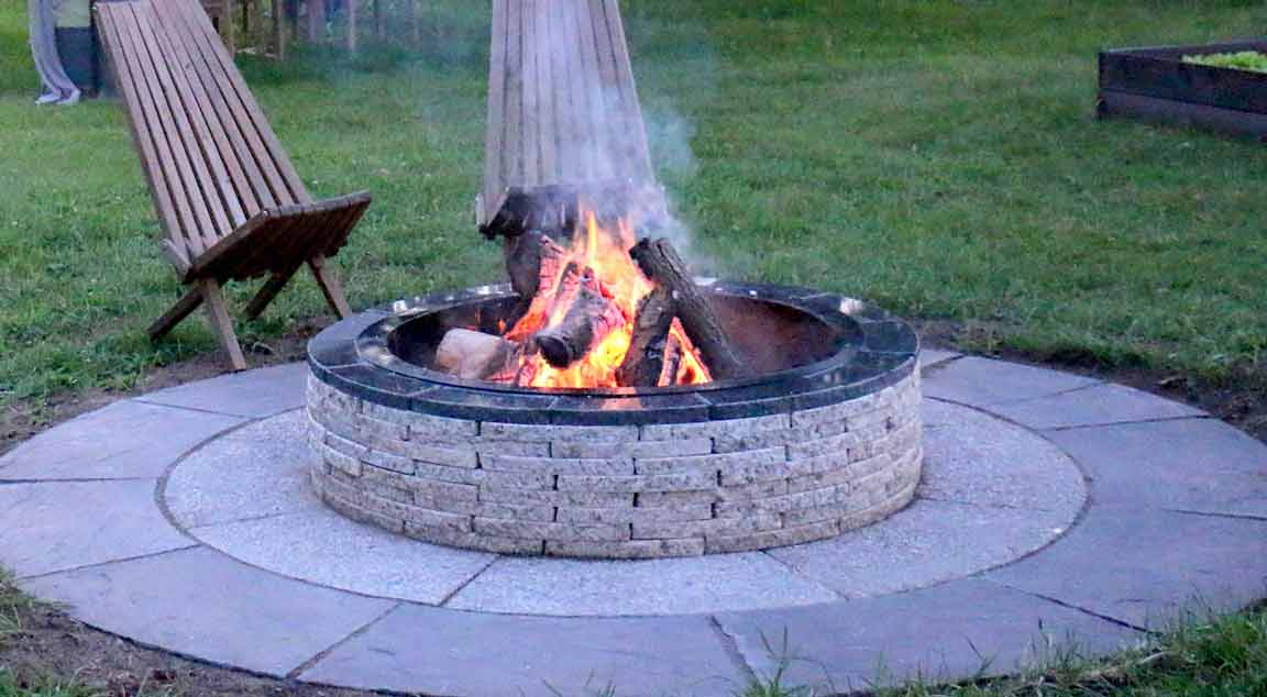 outdoor wood fire pit-with-paving-stones-and-flames