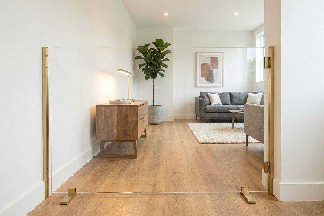 A luxury clear acrylic plexiglass apartment dog barrier placed across a modern apartment hallway