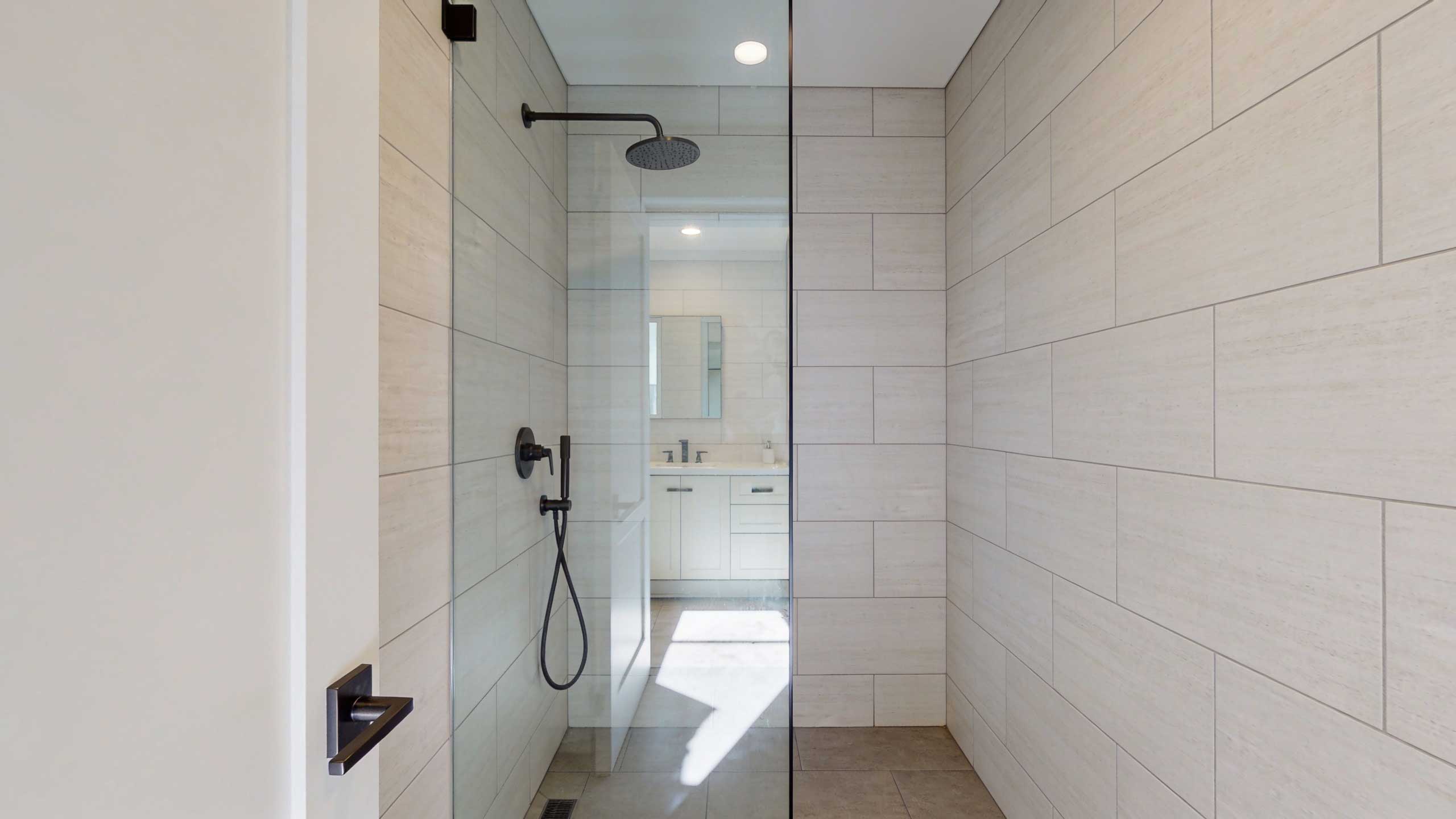 Small bathroom doorless shower with a single fixed clear glass panel