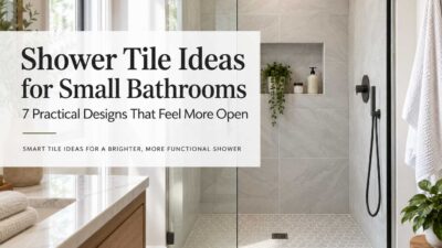 Small bathroom with a walk-in shower, large light wall tiles, hexagonal shower floor tiles, and black fixtures.